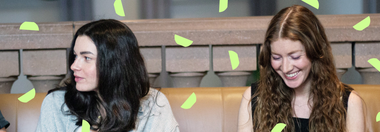 Two colleagues discussing over a laptop with decorative graphics related to AI in digital marketing