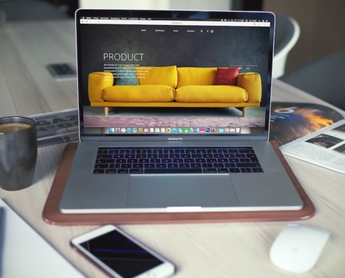 A laptop computer on a desk showing an online shop for furniture