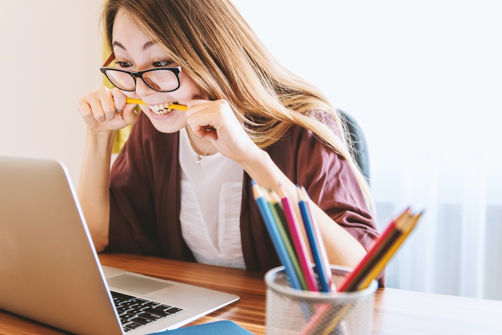 Woman biting pencil.