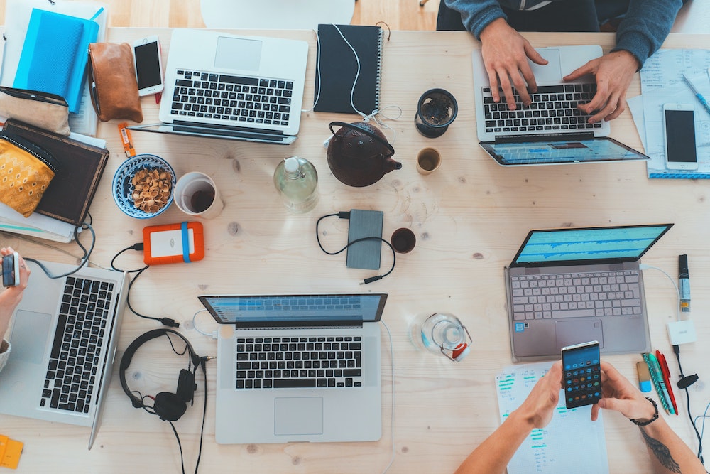 A team of marketers sitting at a table with computers.