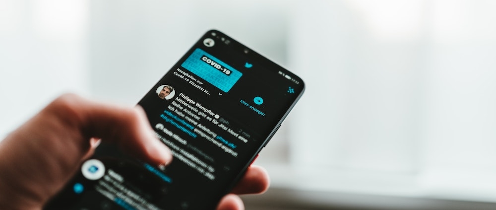 A user scrolling Twitter on their phone.